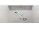 Close-up view of laundry room hookups and shelving with neutral paint at 25235 N 183Rd Dr, Wittmann, AZ 85361