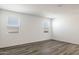 Spacious living room featuring wood-look flooring and natural light from multiple bright windows at 25235 N 183Rd Dr, Wittmann, AZ 85361