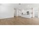 Bright, open-concept living room and kitchen with wood-look tile flooring and modern white cabinets at 25235 N 183Rd Dr, Wittmann, AZ 85361