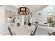 Open dining area with a view of the kitchen and living area; modern chandelier above at 25555 N Windy Walk Dr # 64, Scottsdale, AZ 85255