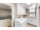 Bright laundry room with garage access, white cabinets, and a sink under a window at 25555 N Windy Walk Dr # 64, Scottsdale, AZ 85255