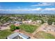 Expansive aerial view of a rural property featuring a large grassy field, outbuildings, and distant mountain views at 26232 S Lemon Ave, Queen Creek, AZ 85142
