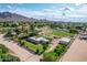 Aerial view showcasing the home, pool, detached garage and surrounding greenery, mountains in background at 26232 S Lemon Ave, Queen Creek, AZ 85142