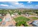 Wide aerial shot shows a property with a large grassy field, various outbuildings, and residential homes under a bright sky at 26232 S Lemon Ave, Queen Creek, AZ 85142