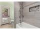 Tiled bathroom featuring a shower with rainfall shower head and toiletry storage at 26232 S Lemon Ave, Queen Creek, AZ 85142