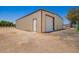 Metal storage shed featuring a roll up door and separate entrance door at 26232 S Lemon Ave, Queen Creek, AZ 85142