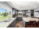 Well-lit kitchen with stainless steel appliances, granite countertops, gray cabinets and a large window with a beautiful green outdoor view at 26232 S Lemon Ave, Queen Creek, AZ 85142