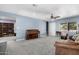 Spacious living room with blue walls, piano, neutral carpet, and ample space for entertaining at 26232 S Lemon Ave, Queen Creek, AZ 85142