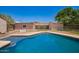 A sparkling in-ground pool with dark blue water is fenced and surrounded by lush green grass at 26232 S Lemon Ave, Queen Creek, AZ 85142