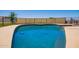 A sparkling in-ground pool with dark blue water is fenced and surrounded by lush green grass at 26232 S Lemon Ave, Queen Creek, AZ 85142