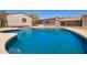 A sparkling in-ground pool with dark blue water is fenced and surrounded by lush green grass at 26232 S Lemon Ave, Queen Creek, AZ 85142