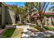 Landscaped walkway between residential buildings with mature trees and flowering bushes at 2929 W Yorkshire Dr # 2074, Phoenix, AZ 85027