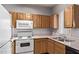 Functional kitchen features wood cabinets, essential white appliances, and a double sink at 2929 W Yorkshire Dr # 2074, Phoenix, AZ 85027