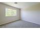 Bright bedroom featuring neutral walls, carpet flooring, and a large window bringing in natural light at 3018 W Horsham Dr, Phoenix, AZ 85027