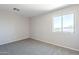 Bright bedroom featuring neutral walls, carpet flooring, and a window offering outdoor views at 3018 W Horsham Dr, Phoenix, AZ 85027