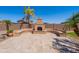 Outdoor patio features an outdoor fireplace with stone seating and palm trees at 30277 N 125Th Ln, Peoria, AZ 85383