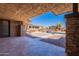 Outdoor patio features a textured ceiling, stone pillars, and a beautiful view of the pool and backyard at 30277 N 125Th Ln, Peoria, AZ 85383