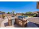 Backyard cooking area with stainless steel appliances, stone countertop, built-in grill and swimming pool views at 30277 N 125Th Ln, Peoria, AZ 85383