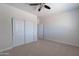 Neutral bedroom with ceiling fan, carpet, closet with sliding doors and entry to another room at 30277 N 125Th Ln, Peoria, AZ 85383