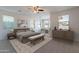 Bright bedroom with neutral tones, offering multiple windows, ceiling fan, and comfortable furniture at 30277 N 125Th Ln, Peoria, AZ 85383