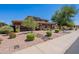 A charming house featuring desert landscaping, decorative rocks, and beautiful green trees at 30277 N 125Th Ln, Peoria, AZ 85383