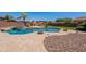 Gorgeous backyard with a sparkling pool, spa, outdoor fireplace, and manicured landscaping at 30277 N 125Th Ln, Peoria, AZ 85383