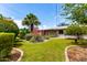 Beautifully landscaped backyard with lush lawn, flowers, plants, and a charming stone border at 3031 E Avalon Dr, Phoenix, AZ 85016