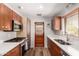 Well-lit kitchen featuring wooden cabinets, stainless steel appliances, and a double basin sink at 3031 E Avalon Dr, Phoenix, AZ 85016