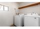Bright laundry room featuring newer front-loading washer and dryer units, and floating shelves at 3031 E Avalon Dr, Phoenix, AZ 85016