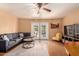 Cozy living room featuring a gray sofa, ceiling fan, and access to the outdoor space through glass doors at 3031 E Avalon Dr, Phoenix, AZ 85016