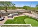 Outdoor kitchen and BBQ island, dining area, green lawn, and putting green for outdoor enjoyment and entertaining at 31256 N 40Th Pl, Cave Creek, AZ 85331
