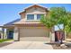 Inviting two-story home featuring a two-car garage, tiled roof, solar panel, and beautiful tree at 31256 N 40Th Pl, Cave Creek, AZ 85331