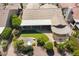 Aerial view of the property's backyard featuring a patio, covered seating area, pond, and desert landscaping at 3394 N 147Th Ln, Goodyear, AZ 85395