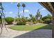 A beautifully landscaped backyard with a pond, mature trees, and lush green grass at 3394 N 147Th Ln, Goodyear, AZ 85395