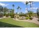 Lush backyard featuring a pond, rock waterfall, and vibrant landscaping at 3394 N 147Th Ln, Goodyear, AZ 85395