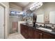 A bathroom featuring a double sink vanity with a granite countertop and a walk-in shower at 3394 N 147Th Ln, Goodyear, AZ 85395