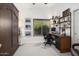 A bedroom features a desk, a window for natural light, and custom shelving and storage at 3394 N 147Th Ln, Goodyear, AZ 85395