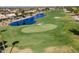 Aerial shot of a beautiful golf course with ponds, green grass, and tree-lined fairways, offering a picturesque view at 3394 N 147Th Ln, Goodyear, AZ 85395
