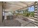 An outdoor kitchen featuring a built-in grill, fire pit, and pergola-covered patio at 3394 N 147Th Ln, Goodyear, AZ 85395