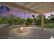 Outdoor patio features a fire pit, desert landscaping, and pergola providing shade on a hardscaped surface at 3394 N 147Th Ln, Goodyear, AZ 85395