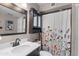 Bathroom featuring dark vanity, framed mirror, and floral shower curtain at 3636 W Crocus Dr, Phoenix, AZ 85053