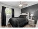 Cozy bedroom with black accent wall, ceiling fan, and natural light from the window at 3636 W Crocus Dr, Phoenix, AZ 85053