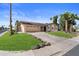 Charming home with a two-car garage, green lawn, desert landscaping, and inviting curb appeal at 3636 W Crocus Dr, Phoenix, AZ 85053