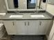 Bathroom featuring double sinks with gray countertops, white cabinets, and silver hardware at 3677 E Park Ave, Gilbert, AZ 85234