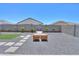 Landscaped backyard including gravel, patio, and fire pit area at 37903 W San Clemente St, Maricopa, AZ 85138
