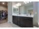 Bright bathroom features a double vanity, dark cabinetry, and a view into the closet at 37903 W San Clemente St, Maricopa, AZ 85138