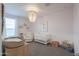 Charming Bedroom featuring a crib, rocking chair, beaded chandelier, and soft pink walls at 37903 W San Clemente St, Maricopa, AZ 85138