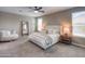 Calm bedroom with neutral walls, carpet flooring, a ceiling fan and an accent chair at 37903 W San Clemente St, Maricopa, AZ 85138