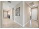 Bright hallway with tile flooring and decorative picture frames adorning the light beige walls at 37903 W San Clemente St, Maricopa, AZ 85138