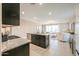 Open kitchen features granite countertops, stainless steel appliances, and island with barstool seating at 37903 W San Clemente St, Maricopa, AZ 85138